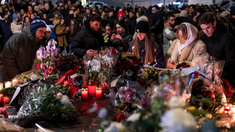 Warga dan wisatawan menyalakan lilin di salju depan reruntuhan Le Constellation Bar di Crans-Montana sebagai penghormatan kepada korban kebakaran Tahun Baru.