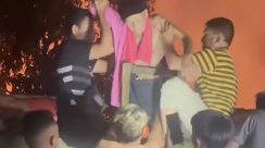 Petugas polisi dan warga mengevakuasi lansia saat terjadi kebakaran Panti Jompo Werdha Damai di Manado.