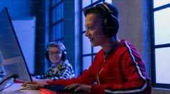 Seorang remaja bermain gim online di kamar, menggambarkan ancaman radikalisasi digital yang menyusup ke dunia anak-anak Indonesia.