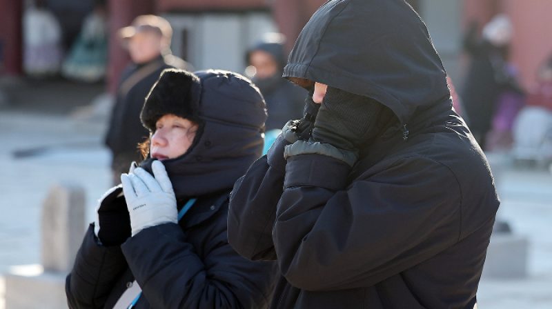 Orang-orang mengenakan mantel tebal, syal, dan sarung tangan berjalan di jalan dekat Istana Gyeongbok, Distrik Jongno, pusat Seoul, pada 25 Desember. Foto: Korea Joongang Daily for Hallonews