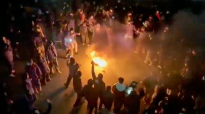 Pengunjuk rasa mengelilingi api di jalanan Teheran pada malam hari saat protes anti-pemerintah meningkat.