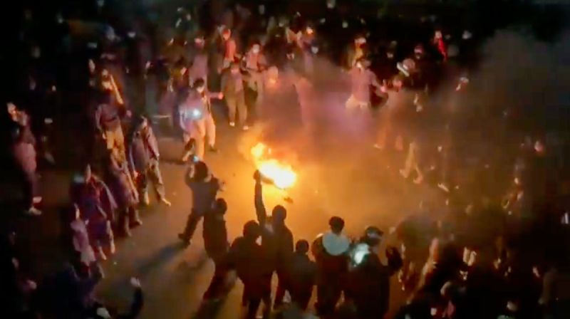 Pengunjuk rasa mengelilingi api di jalanan Teheran pada malam hari saat protes anti-pemerintah meningkat.