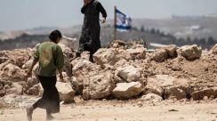 Seorang pemukim Israel berjalan di Tepi Barat