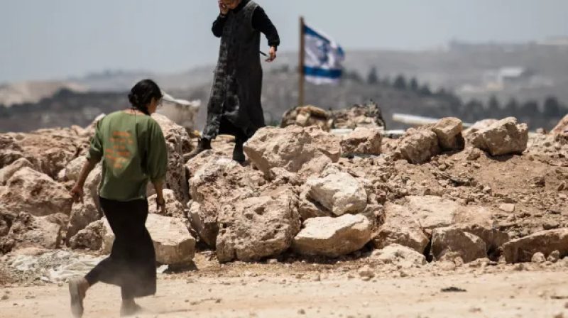 Seorang pemukim Israel berjalan di Tepi Barat