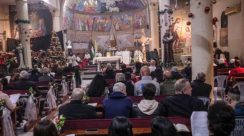 Umat Kristiani berkumpul di Gereja Keluarga Kudus, Gaza, merayakan misa malam Natal pertama setelah dua tahun perang. Pohon Natal kembali menyala di tengah doa, luka, dan harapan. Foto: Al Jazeera for Hallonews